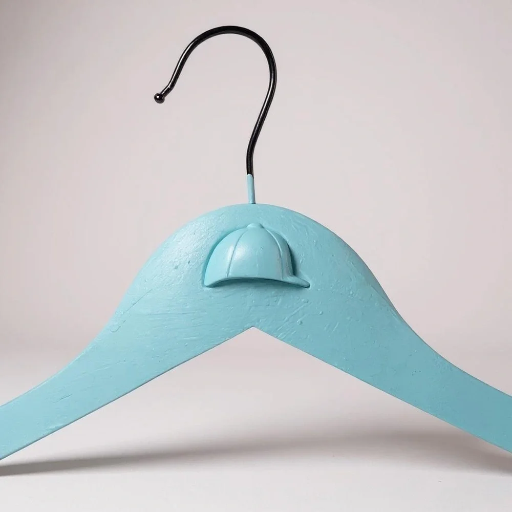 Teal Hanger with Angled Shoulders for the Equestrian attire adorned with helmet.